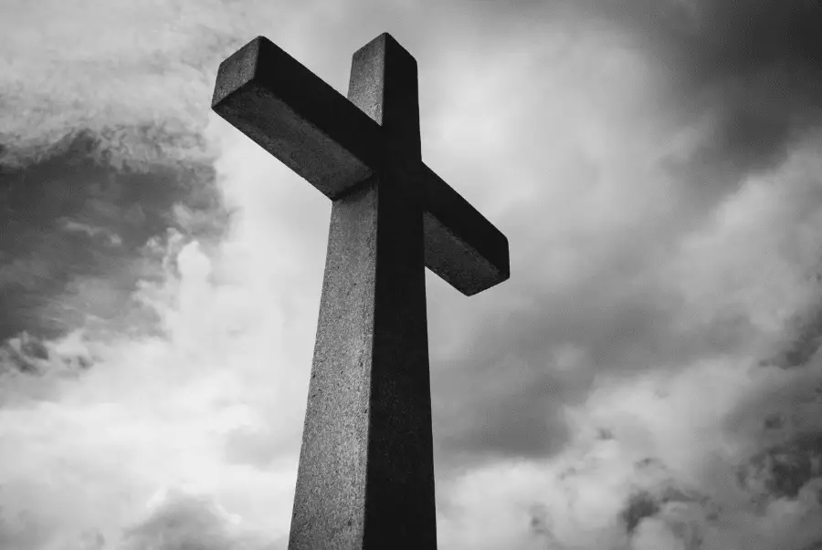 Black And White Photo Of Stone Cross With The Sky And Clouds Behind It