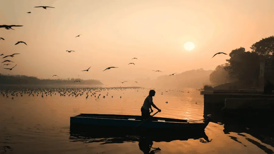 Man In Wooden Boat In Lake