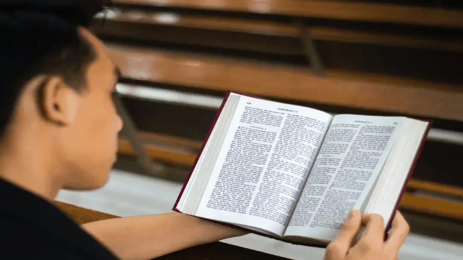 Man Reading Bible In Pew 900x506