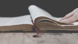 Bible Turning Page On Wood Table 356x200