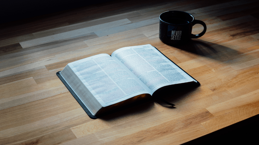 Bible On Table With Cup Never Settle 900x506